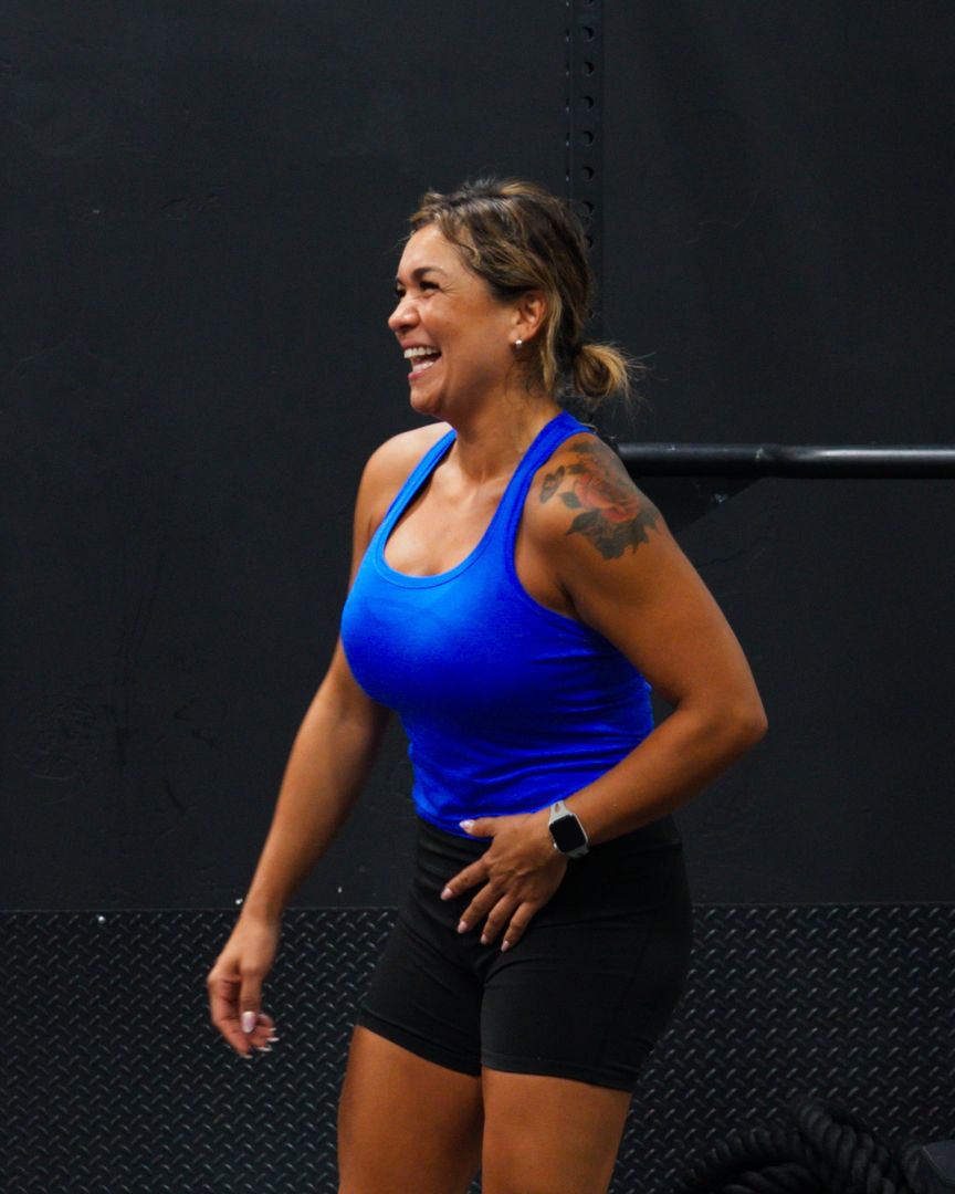 A member laughing between sets on the weight floor